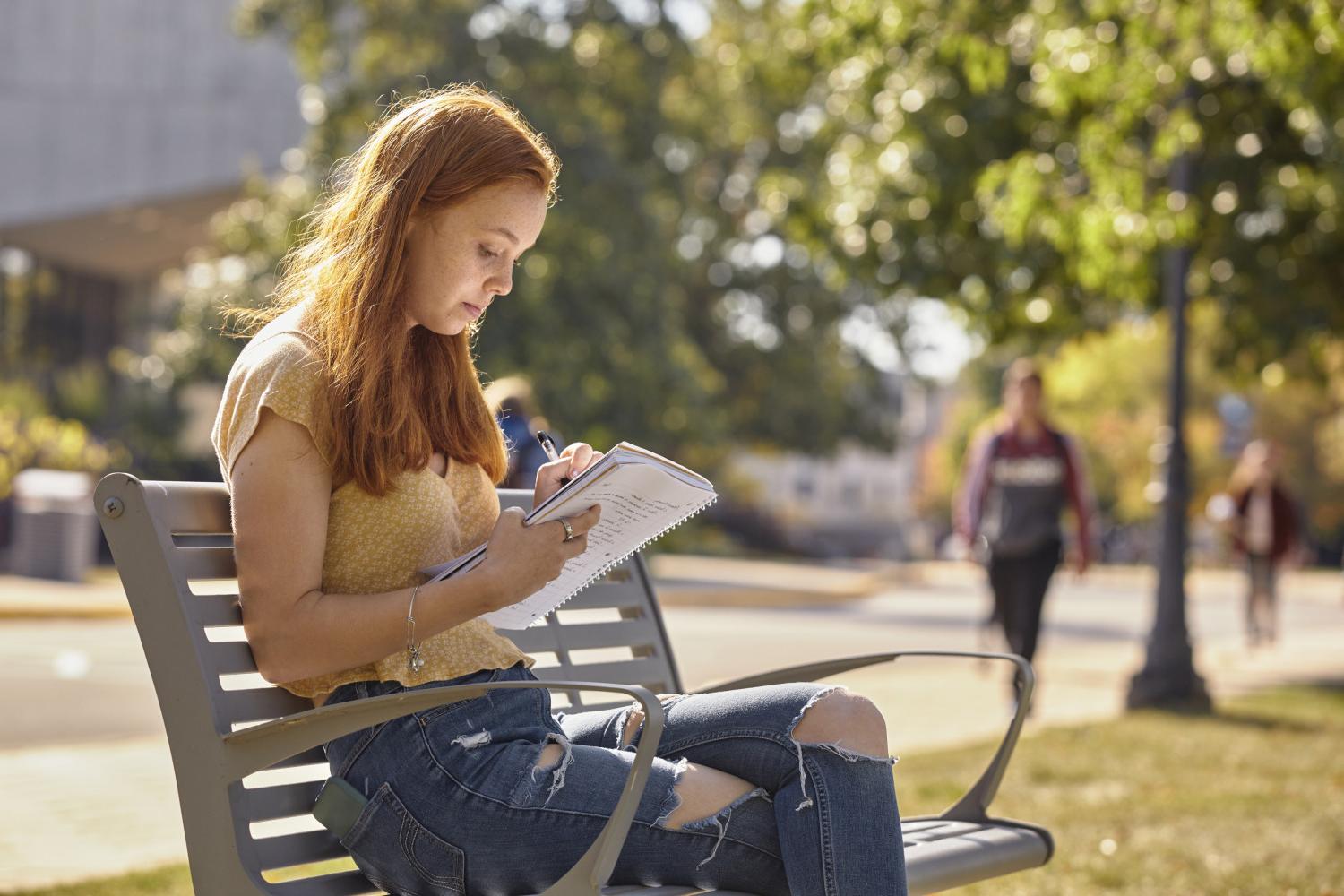 一位<a href='http://fvwcvk.annccb.com'>博彩网址大全</a>学院的学生在校园里的长椅上读书.